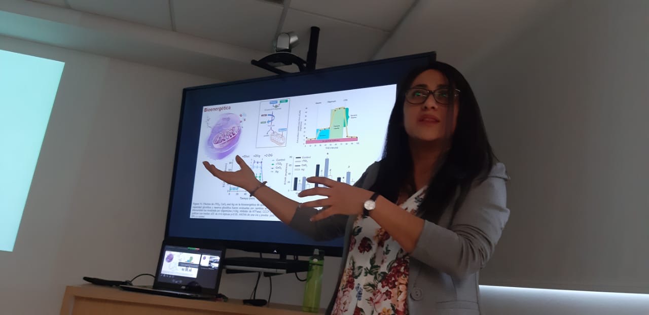 Veronica Montesinos-Cruz presenting in front of a screen showing a slide